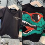 Short-Sleeved T-shirt - Classic black base with "FANTASTIC I BELL" printed on the front chest and  a teal and red dinosaur graphic