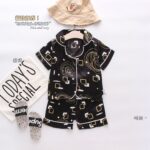 Golden Swirl Black Pajamas - A sleek black satin pajama set with an abstract gold and white geometric pattern