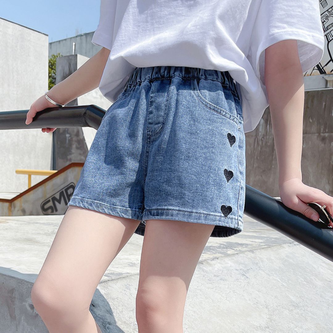 11646 The Black Heart Denim Short - Comfortable mid-wash blue denim shorts featuring cute black embroidered hearts down the side - Image 1